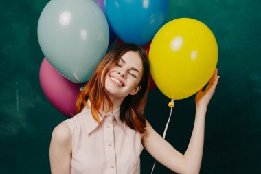 Neşeli bir kadın renkli balonlarla doğum günü eğlencesi