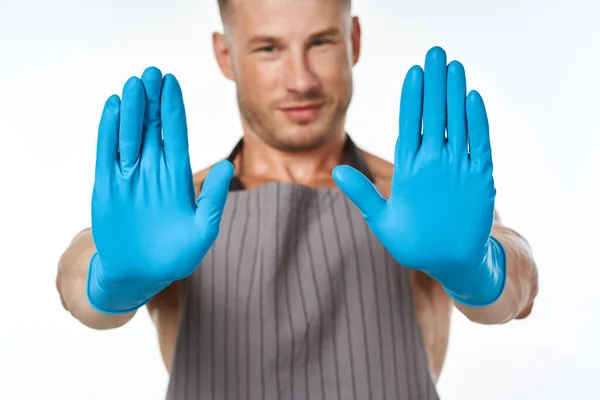 エプロンを手にした青いゴム手袋の男は — ストック写真