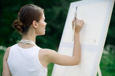 Kadın sanatçı doğa palet tablosu çizer yaratıcı manzara