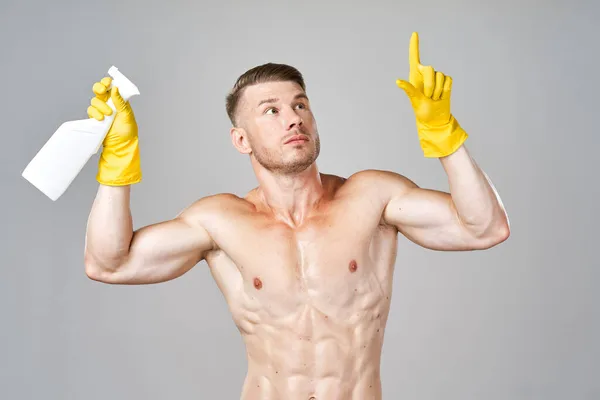 Muž s napumpovaným svalové tělo prací gumové rukavice — Stock fotografie