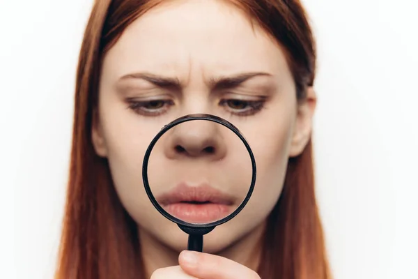 Jolie femme grimacant avec loupe près du visage gros plan — Photo