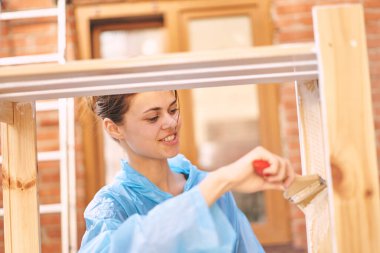 Kadın boyacı evde ahşap döşemeleri yeniliyor.