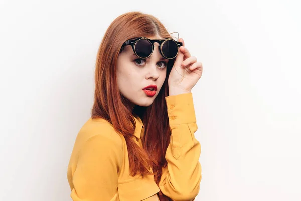 Glamourosa mulher óculos de sol vermelho cabelo luz fundo — Fotografia de Stock