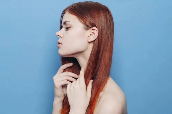 Mulher atraente com ombros nus cabelo vermelho close-up fundo azul — Fotografia de Stock