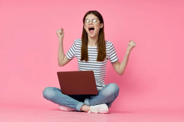 Mujer con portátil en rosa fondo de compras en línea entretenimiento — Foto de Stock