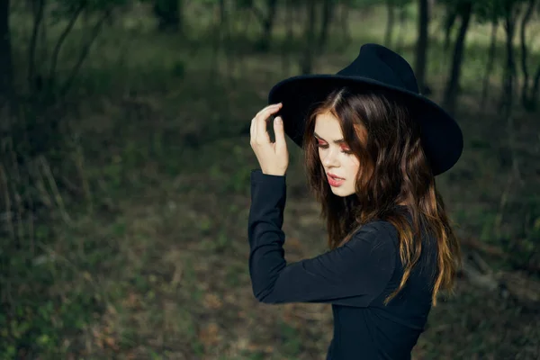 Woman in the forest in a black hat gothic style Witch costume — Stock Photo, Image