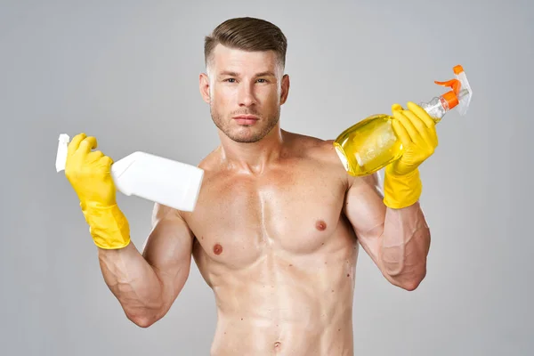 Hombre con bombeo hasta cuerpo muscular detergente guantes de servicio de goma —  Fotos de Stock