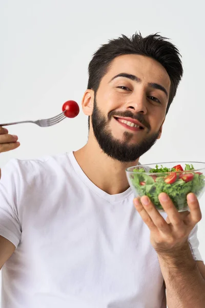 Cheerful man in a white T-shirt with a plate of light green and a healthy meal — Stock Photo, Image