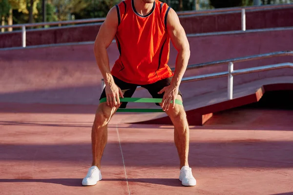 Athletischer Mann auf dem Sportplatz Gummiband-Übung — Stockfoto