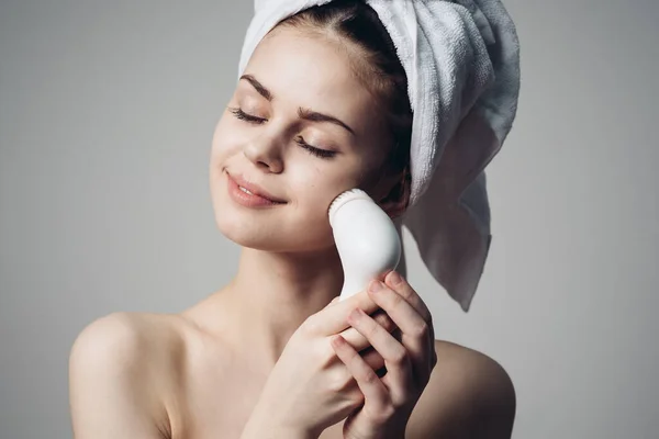Женщина с полотенцем на голове массажер уход за кожей лица гигиены — стоковое фото
