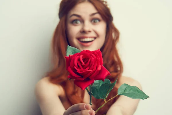 Hermosa mujer con el pelo rojo rosa roja flor de cerca —  Fotos de Stock