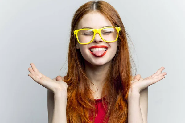 Mooie vrouw geel bril en rode lippen mode licht achtergrond — Stockfoto