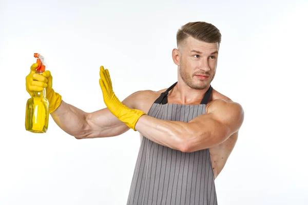 Hombre alegre en delantal detergente posando músculos — Foto de Stock