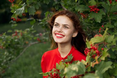 Kırsal alanda kırmızı gömlekli neşeli bir kadın.