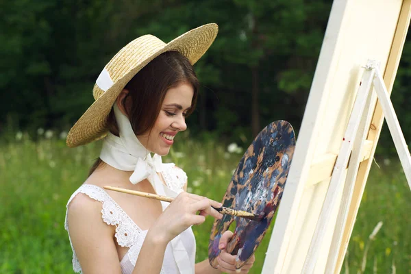 Жінка в білій сукні на відкритому повітрі художник малює мольберт — стокове фото