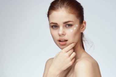 Çıplak omuzlu kadın yüz kremi cilt bakımına yakın çekim