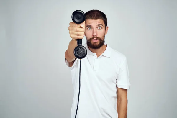 Emotional bearded man talking on the phone light background — Stock Photo, Image