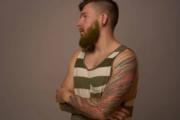 Bearded man in striped t-shirt with tattoos posing studio — Stock Photo, Image