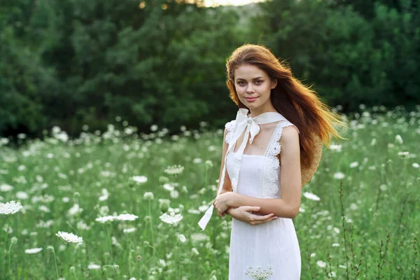 Kvinna i vit klänning i ett fält promenad blommor vintage natur — Stockfoto