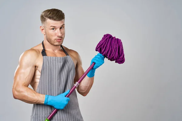 Man in schort met dweil in de hand poseren huishoudelijk werk — Stockfoto