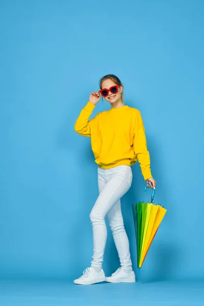 노랑 스웨터를 입고 무지개 색깔을 띠고 있는 여자 — 스톡 사진