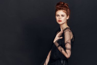 Siyah elbiseli zarif bir kadın kozmetik poz veriyor.