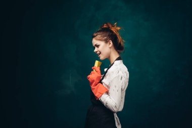 Elinde bez parçasıyla kırmızı lastik eldivenli temizlikçi kadın.