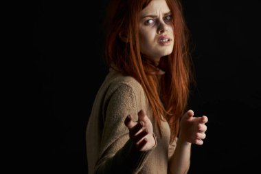 Üzgün kadın ağlıyordu. Gözlerinde morluklar vardı. Karanlık arka plan.