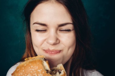 Hamburger yiyen bir kadın.