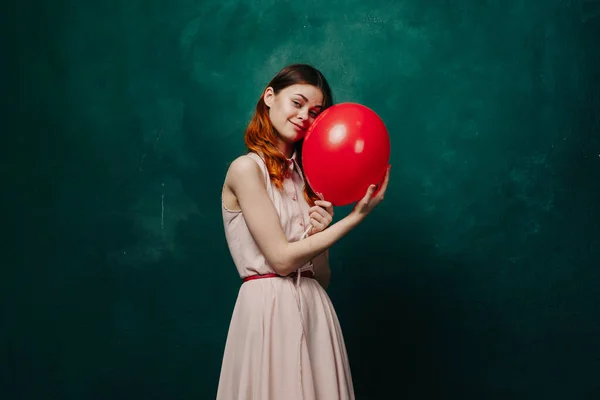 Mujer alegre con globo rojo vacaciones de fondo verde — Foto de Stock