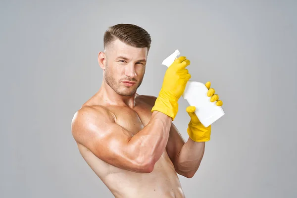 Pompowany człowiek pozowanie z detergentem w gumowych rękawiczkach — Zdjęcie stockowe