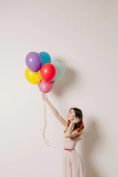 Glad kvinna i en klänning av färgglada ballonger — Stockfoto