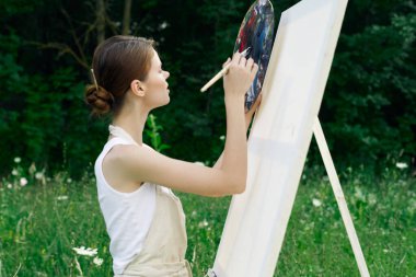 Kadın sanatçı doğa palet tablosu çizer yaratıcı manzara