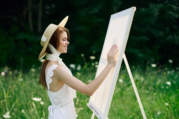 Frau in weißem Kleid in der Natur malt Bild eines Landschaftshobby — Stockfoto