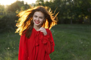 Açık havada kırmızı elbiseli neşeli bir kadın. Temiz hava.