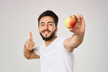 Beyaz tişörtlü sakallı adam, elma sağlığına uygun beslenme.