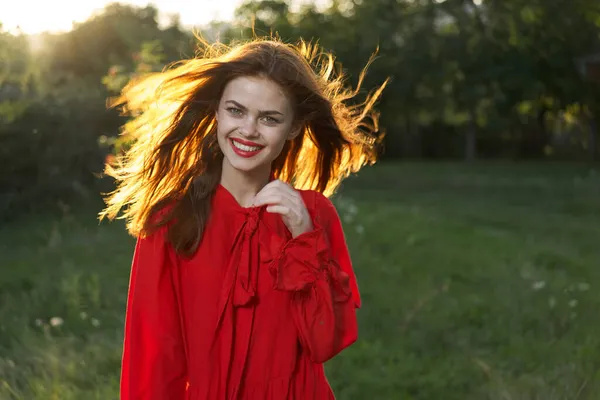 Açık havada kırmızı elbiseli neşeli bir kadın. Temiz hava.