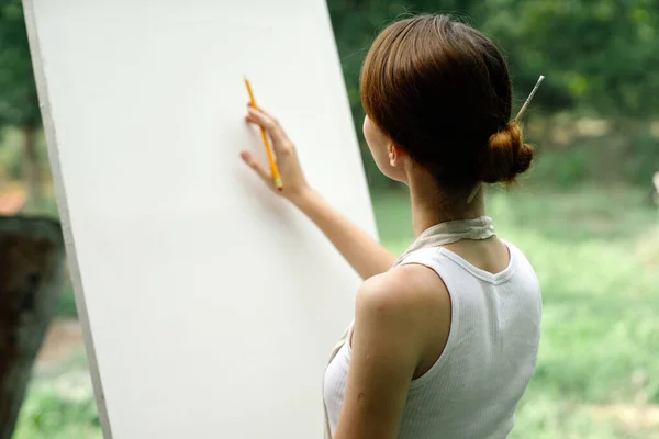 Un artista en la naturaleza se basa en un caballete con un lápiz —  Fotos de Stock