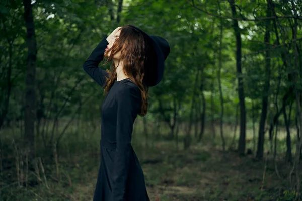 Веселая женщина ведьма в лесу, представляющая фантазию — стоковое фото