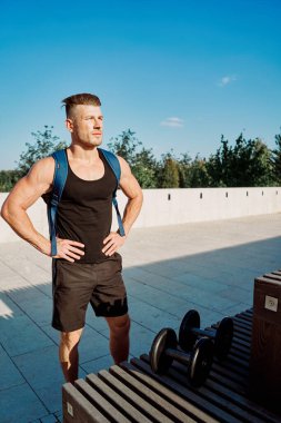 Parktaki spor salonunda vücudunu şişiren atletik adam. Temiz hava.