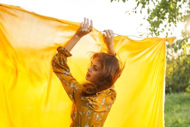 Kadın, doğaya poz veriyor, sarı kumaş temiz hava.