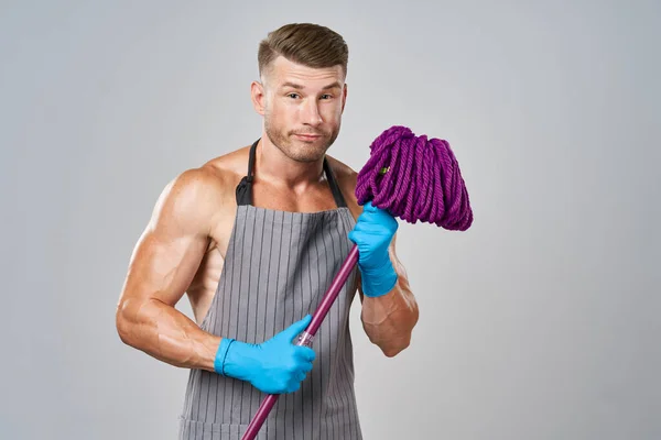 Een man met een dweil in zijn handen schoonmaak dienst poseren — Stockfoto