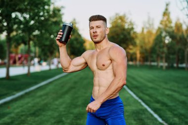 Parktaki egzersiz motivasyonunda kaslı vücutlu atletik bir adam.