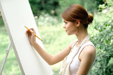 Neşeli kadın sanatçı doğa yaratıcı sanatı canlandırır.