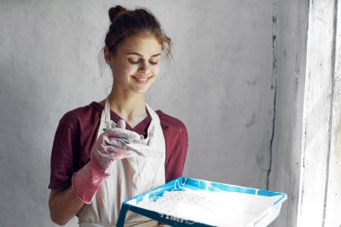 Elinde fırça olan neşeli kadın ressam ev dekorasyonu yaratıcı.