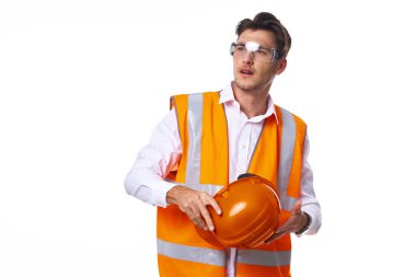 Turuncu üniformalı bir adam inşaat işinde.