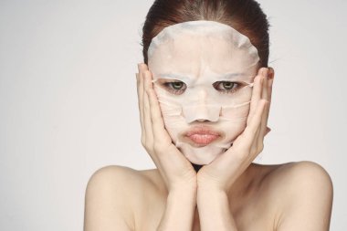 Güzel bir kadın çıplak omuzlarıyla maske takar.
