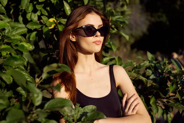 Csinos nő napszemüvegben nyáron szabadban zöld levelek — Stock Fotó