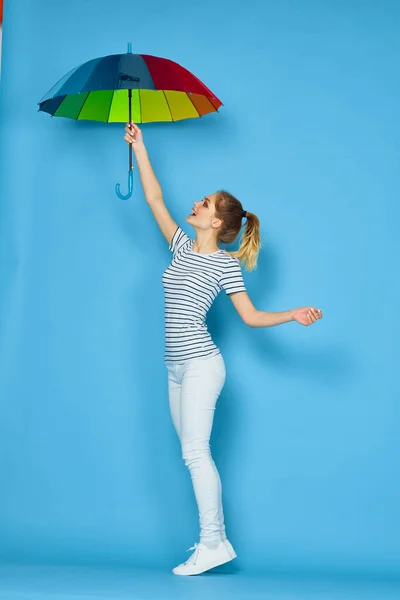 Jolie femme mode posant parapluie coloré fond bleu — Photo