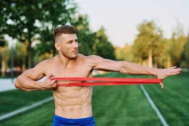 Parkın spor salonunda şişkin vücutlu atletik bir adam.